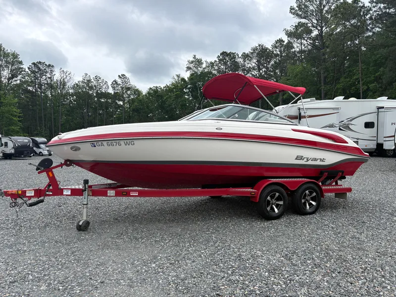 Slide: The Image of Red and white 2012 Bryant 220 boat on trailer, parked on gravel lot. - 1