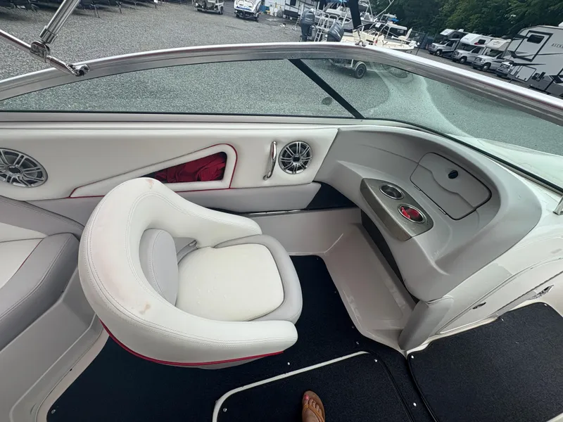 Slide: The Image of Interior of a 2012 Bryant 220 boat with white seating and cup holders. - 11
