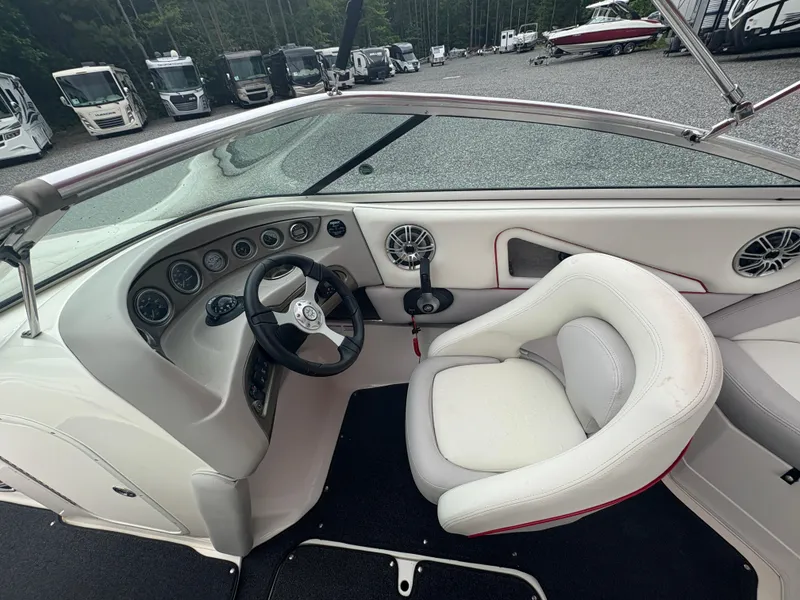 Slide: The Image of Interior of a 2012 Bryant 220 boat with white seating and dashboard controls. - 12