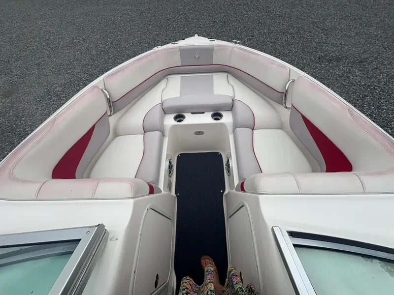 Slide: The Image of 2012 Bryant 220 boat interior with white and red seating, cup holders, and open bow design. - 15