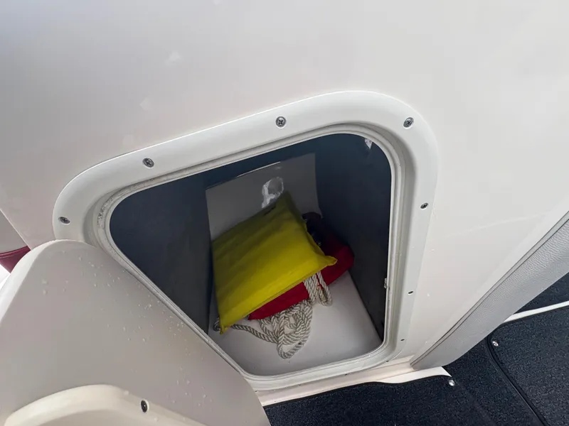 Slide: The Image of Storage compartment in a 2012 Bryant 220 boat, containing safety equipment. - 16