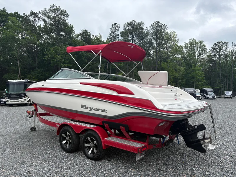 Slide: The Image of Red and white 2012 Bryant 220 boat on trailer, parked outdoors. - 2