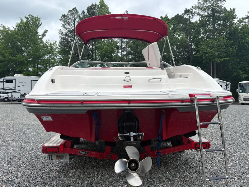 Slide: The Image of Red and white 2012 Bryant 220 boat with ladder and canopy, parked on gravel. - 3