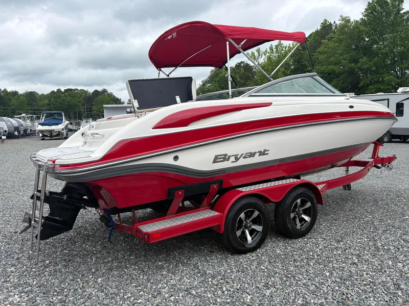Slide: The Image of 2012 Bryant 220 boat with red and white design on a dual-axle trailer. - 4