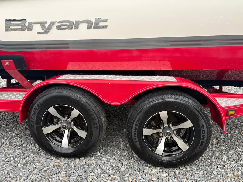 Slide: The Image of Red Bryant 220 boat trailer with dual wheels, 2012 model, on gravel surface. - 6