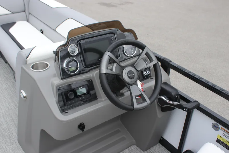 Slide: The Image of 2025 Avalon VENTURE QUAD LOUNGER boat dashboard with steering wheel and controls. - 5