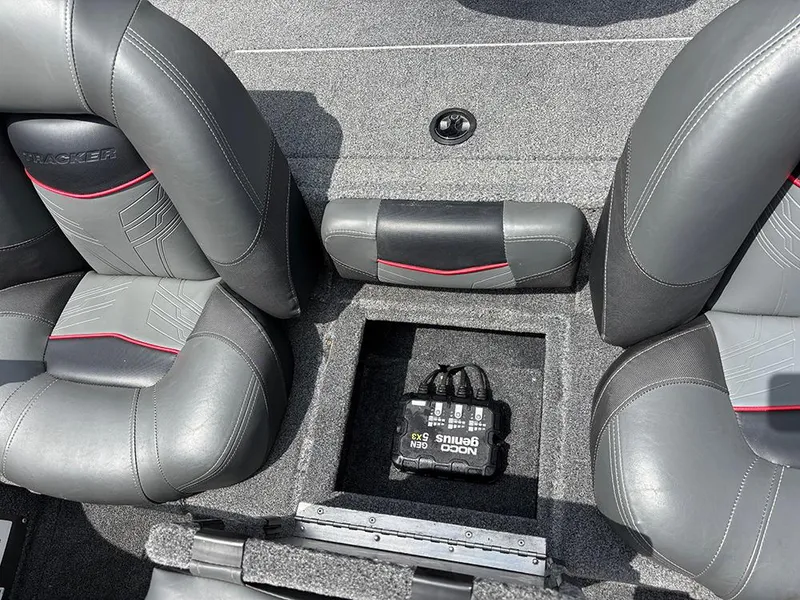 Slide: The Image of 2024 Tracker Pro Team 190 TX boat interior with storage compartment and NOCO Genius charger. - 18