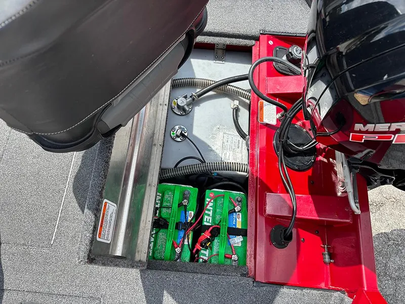 Slide: The Image of 2024 Tracker Pro Team 190 TX boat battery compartment with wiring and engine components. - 24