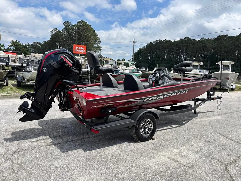 Slide: The Image of 2024 Tracker Pro Team 190 TX boat on trailer, parked outdoors under cloudy sky. - 6