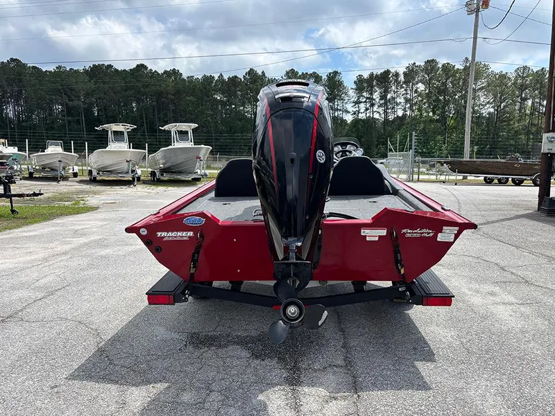 Slide: The Image of 2024 Tracker Pro Team 190 TX boat, red, rear view, parked outdoors. - 7