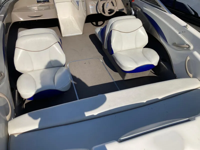 Slide: The Image of 2003 Bayliner 180 Bowrider interior with white and blue seating, steering wheel, and dashboard. - 3