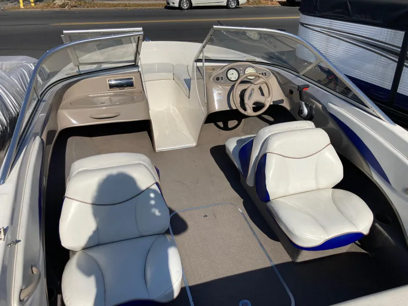 Slide: The Image of 2003 Bayliner 180 Bowrider interior with white seats and steering wheel. - 4