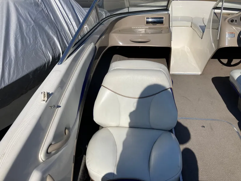 Slide: The Image of 2003 Bayliner 180 Bowrider interior with white seating and dashboard view. - 6