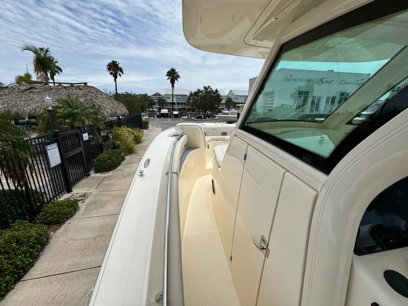 Slide: The Image of 2025 Scout 305 LXF boat docked, showcasing sleek design and spacious deck. - 12