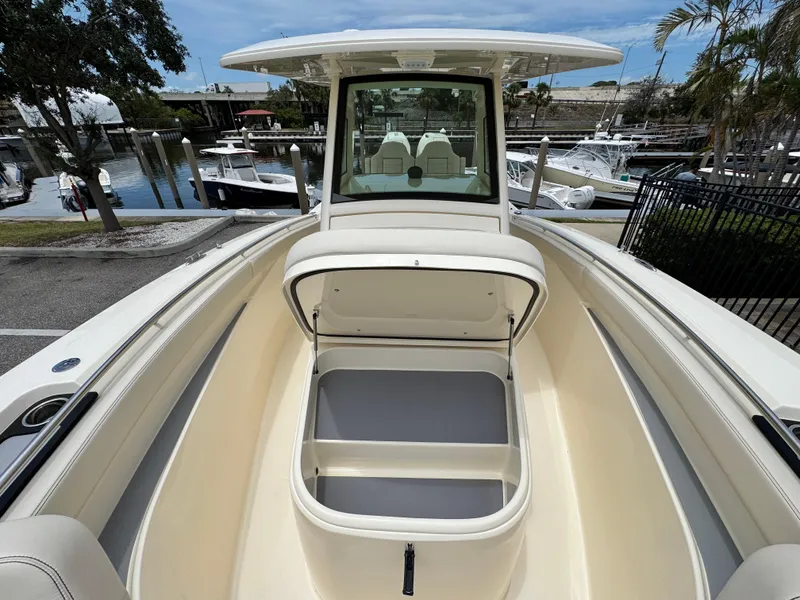 Slide: The Image of 2025 Scout 305 LXF boat with open storage compartment, docked at marina. - 18