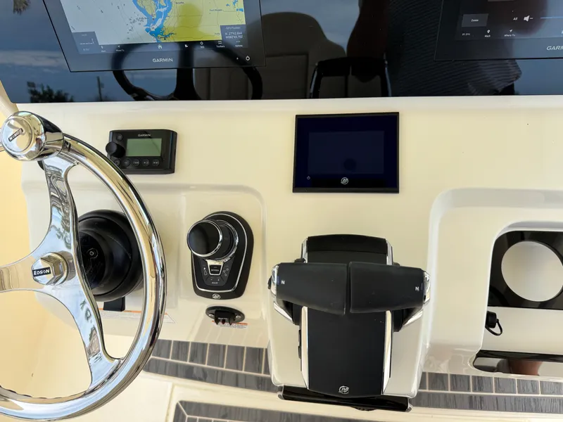 Slide: The Image of 2025 Scout 305 LXF boat dashboard with steering wheel and navigation controls. - 23