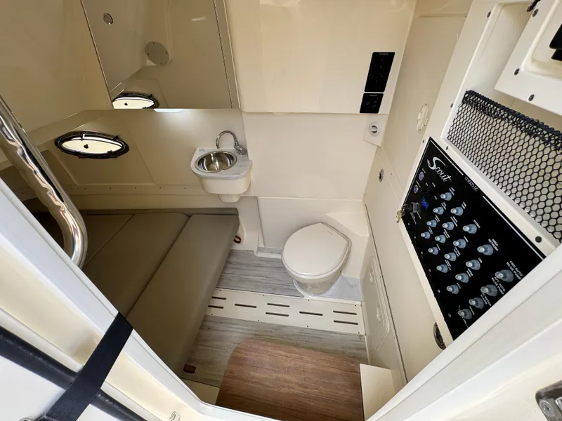 Slide: The Image of 2025 Scout 305 LXF boat interior with sink, toilet, and control panel. - 24