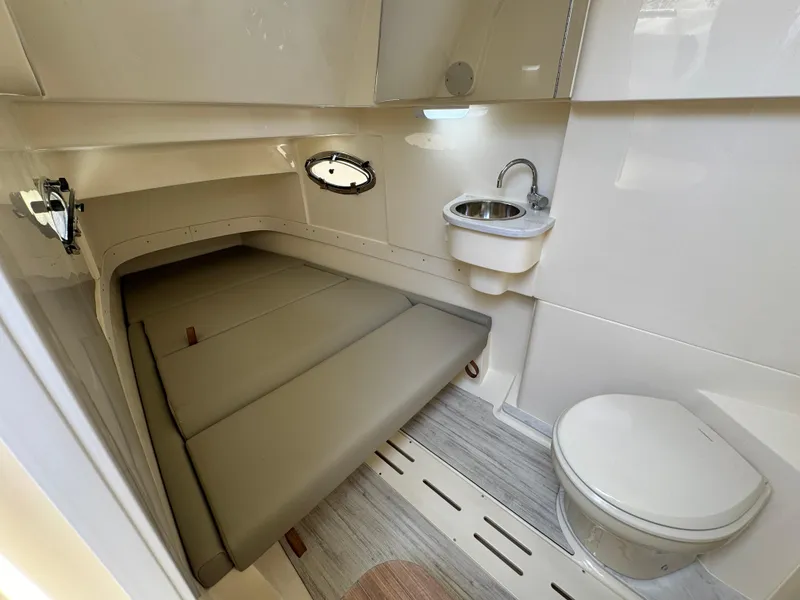 Slide: The Image of 2025 Scout 305 LXF boat cabin with bed, sink, and toilet. - 25