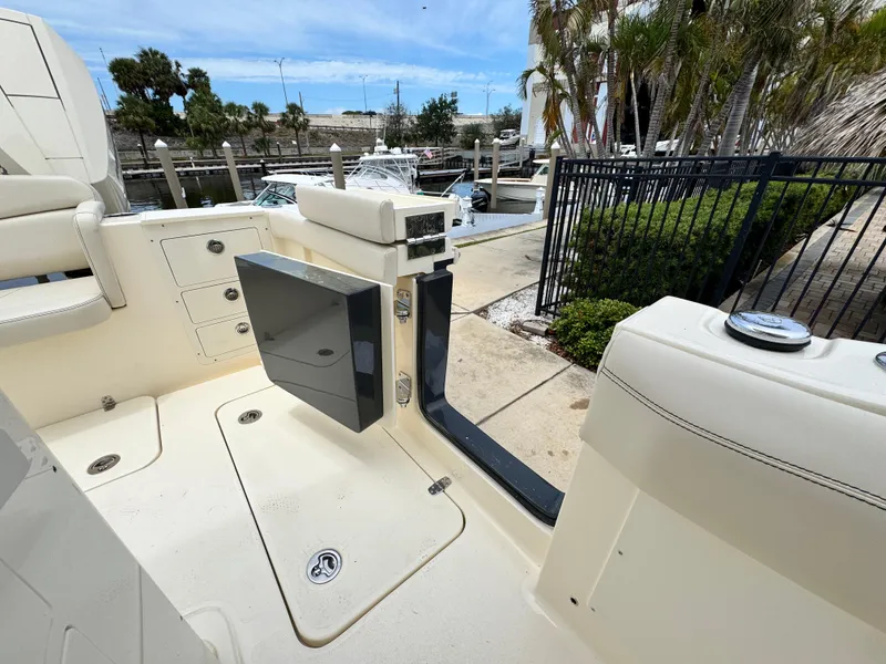 Slide: The Image of 2025 Scout 305 LXF boat interior, featuring open deck and marina view. - 9