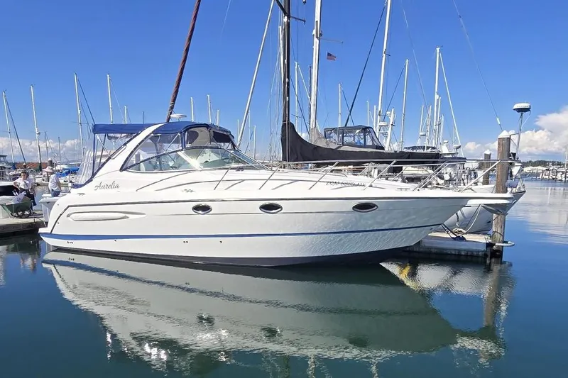 The Image of 2006 Maxum 3300 SE yacht docked in a marina, reflecting on calm water. - 0