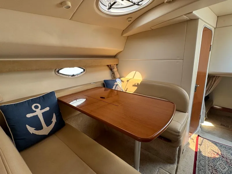 Slide: The Image of 2006 Maxum 3300 SE yacht interior with dining area and anchor-themed pillows. - 12