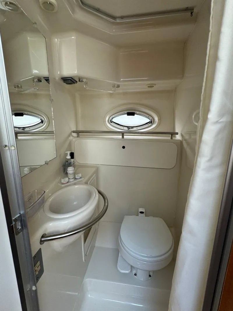 Slide: The Image of 2006 Maxum 3300 SE boat bathroom with sink, toilet, and porthole window. - 16