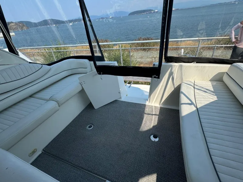 Slide: The Image of 2006 Maxum 3300 SE boat interior with white seating, overlooking scenic waterfront. - 23