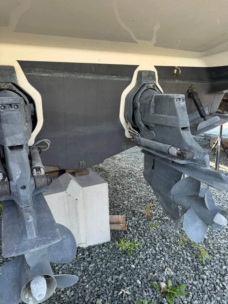 Slide: The Image of 2006 Maxum 3300 SE boat stern with dual propellers on gravel surface. - 28