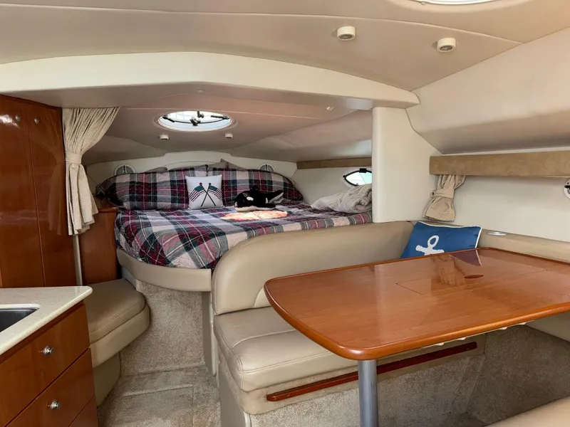 Slide: The Image of 2006 Maxum 3300 SE cabin interior with cozy bed, dining area, and nautical decor. - 5