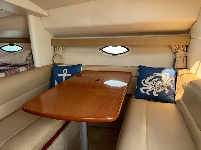 Slide: The Image of Interior of 2006 Maxum 3300 SE boat with cozy seating and nautical-themed cushions. - 7