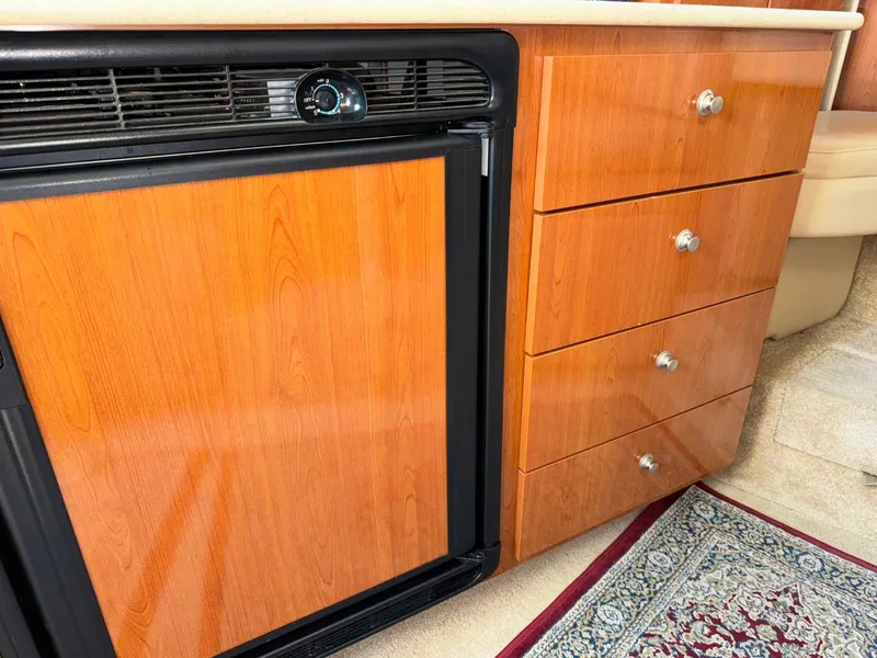 Slide: The Image of 2006 Maxum 3300 SE interior with wood cabinetry and compact refrigerator. - 9