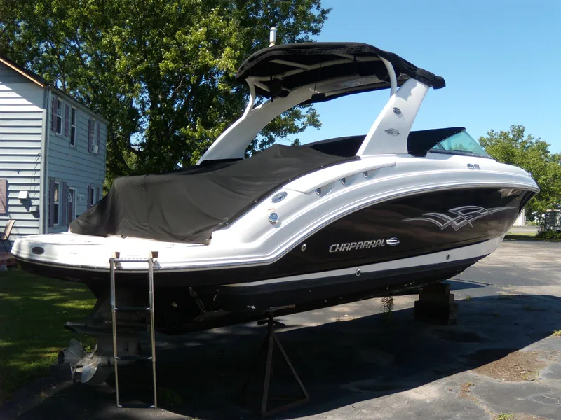 Slide: The Image of 2008 Chaparral SSX 276 boat with black cover, parked outdoors. - 2