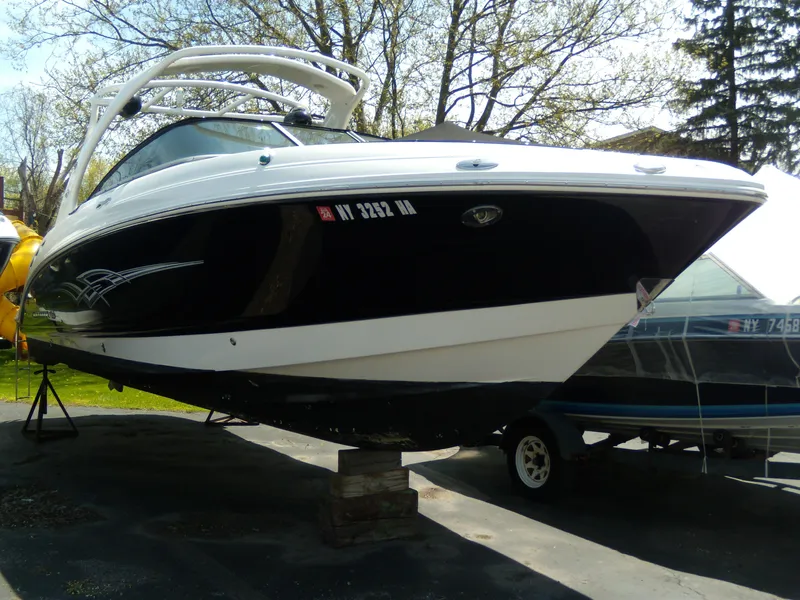 Slide: The Image of 2008 Chaparral SSX 276 boat on display, black and white hull, parked outdoors. - 29