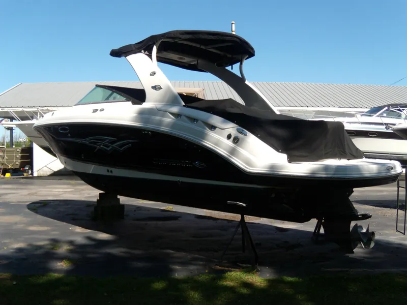 Slide: The Image of 2008 Chaparral SSX 276 boat on stands, covered, outdoors under clear sky. - 4