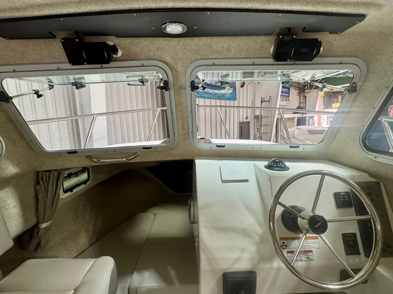 Slide: The Image of Interior view of 2025 Parker 2120 Sport Cabin boat, featuring steering wheel and windows. - 10