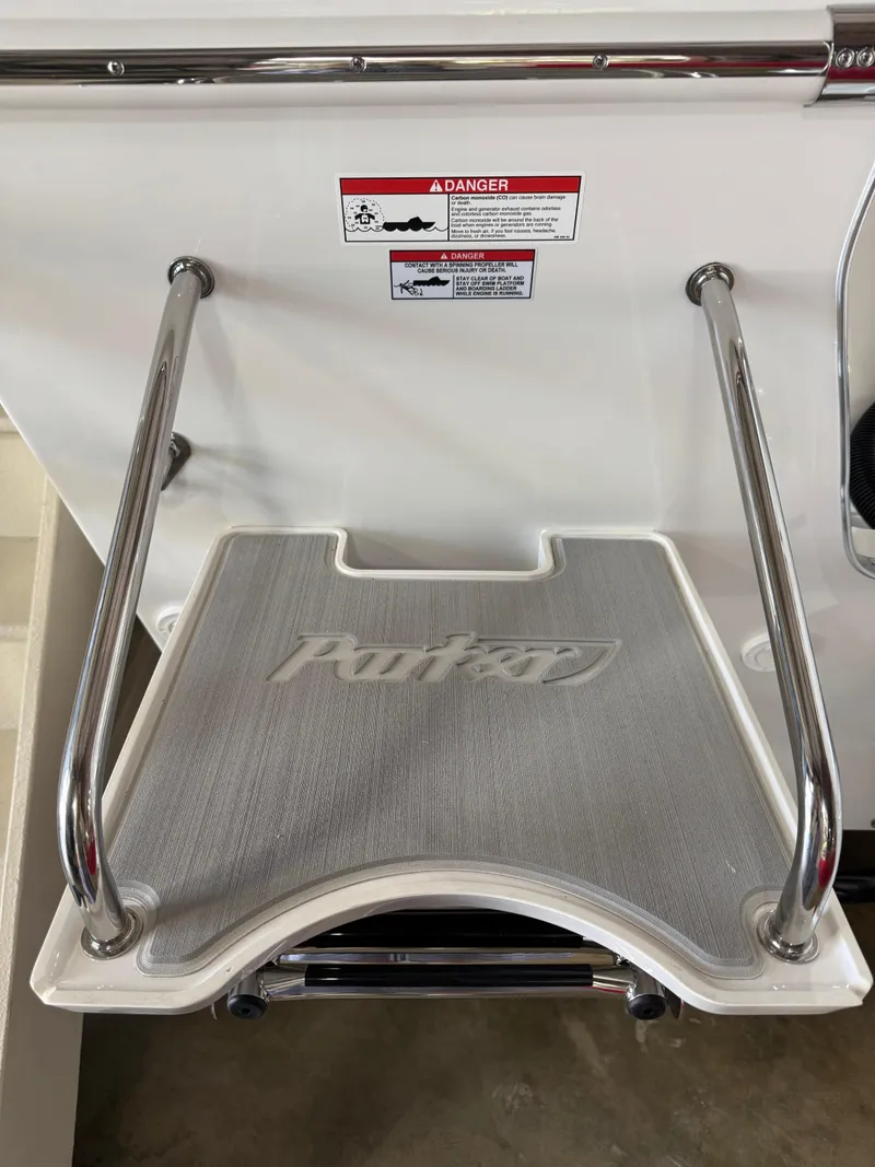 Slide: The Image of 2025 Parker 2120 Sport Cabin swim platform with safety warning label and metal handrails. - 12