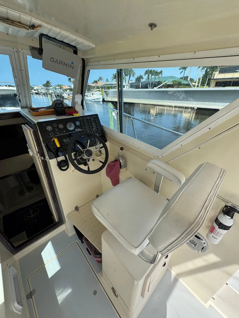 Slide: The Image of 1996 Albin Tournament Express helm with Garmin navigation, dockside view through windows. - 11