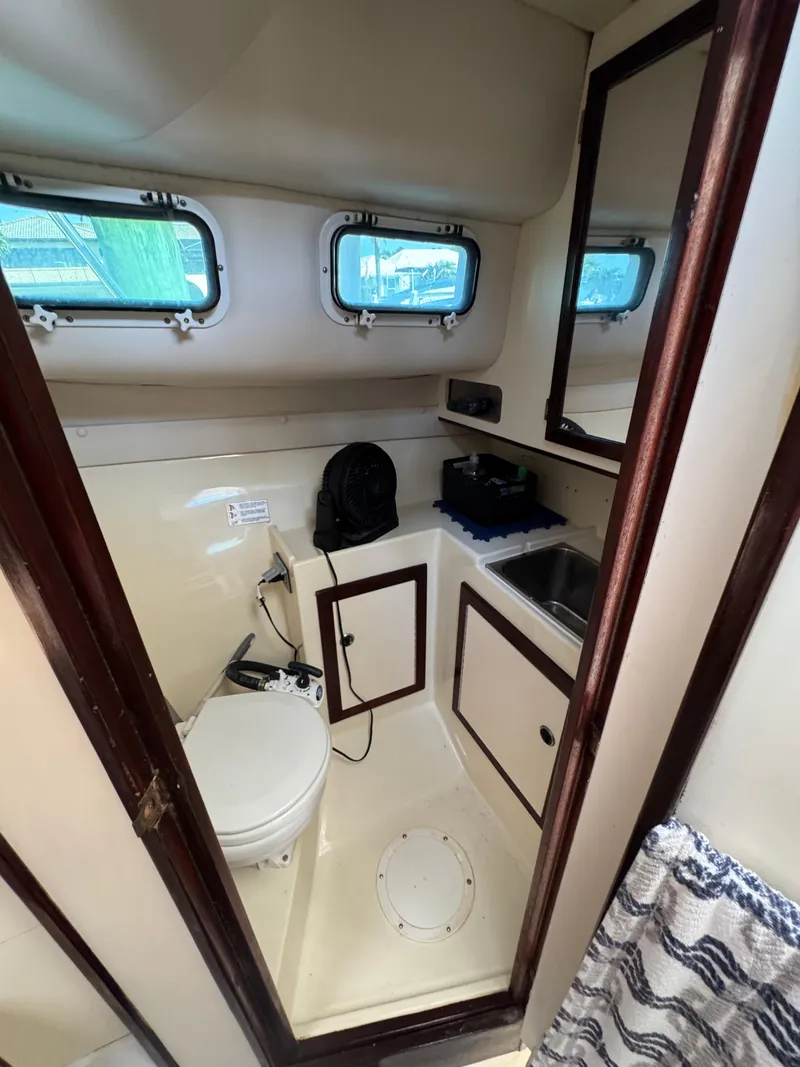 Slide: The Image of 1996 Albin Tournament Express boat bathroom with sink, toilet, and storage cabinets. - 19