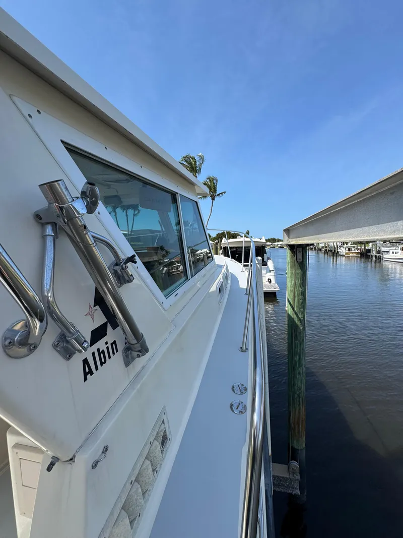 Slide: The Image of 1996 Albin Tournament Express boat docked at marina under clear blue sky. - 2