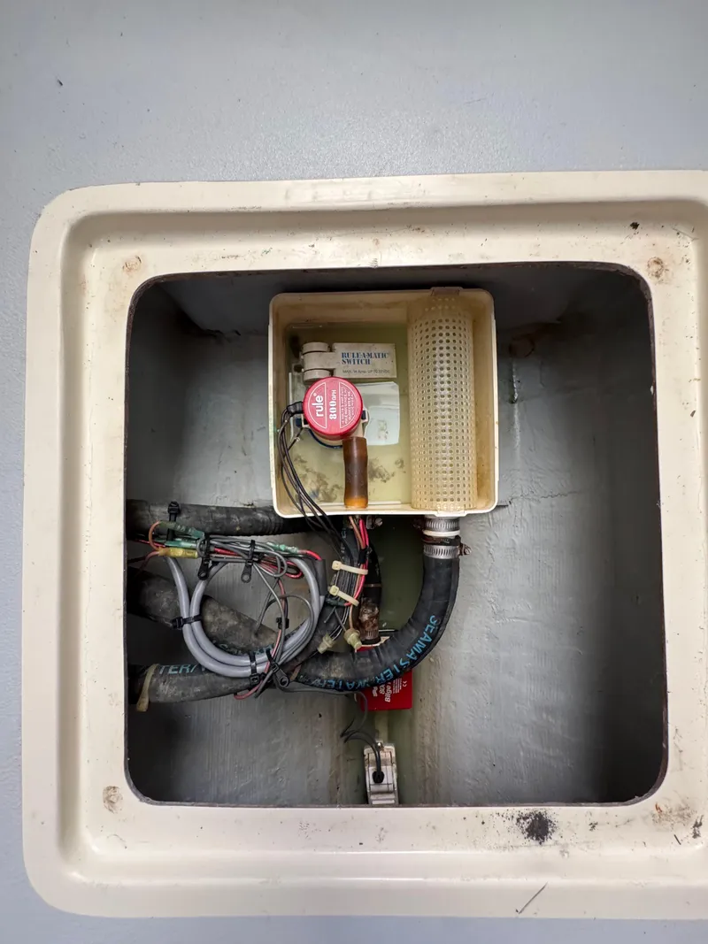 Slide: The Image of 1996 Albin Tournament Express bilge compartment with wiring and pump components. - 22