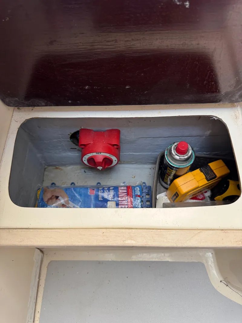 Slide: The Image of Storage compartment in a 1996 Albin Tournament Express boat with tools and supplies. - 27
