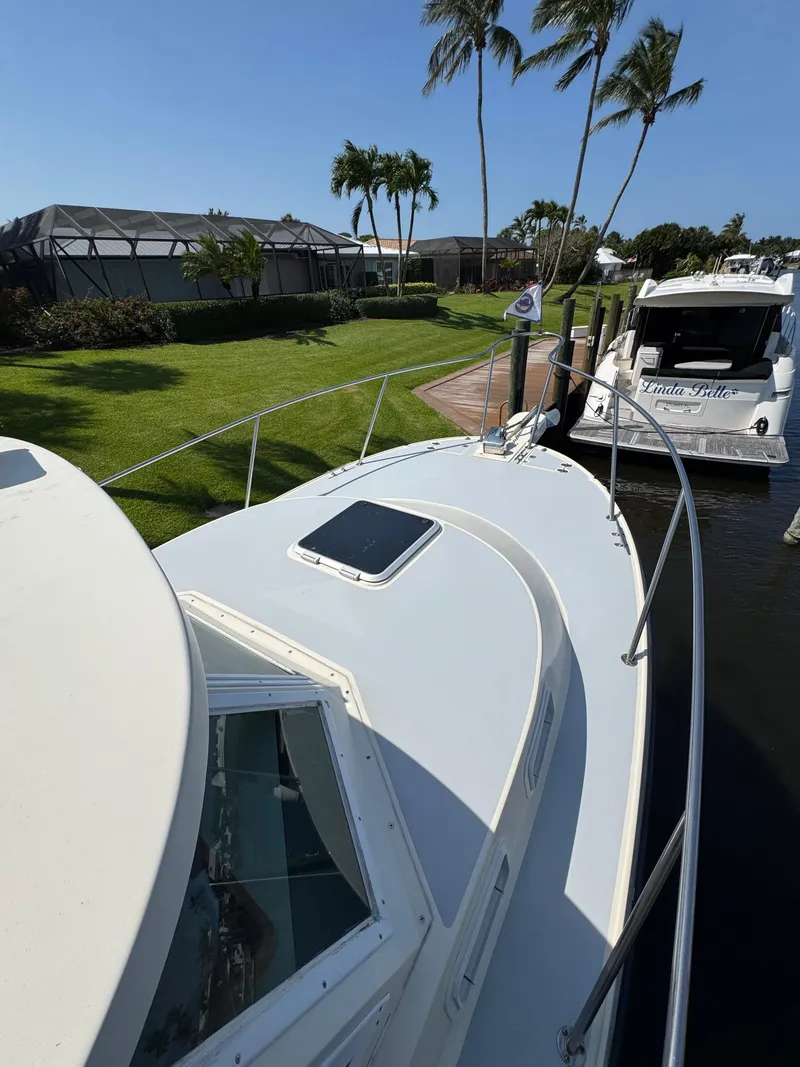 Slide: The Image of 1996 Albin Tournament Express boat docked near palm trees and waterfront homes. - 3