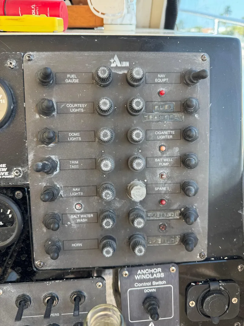 Slide: The Image of Control panel of a 1996 Albin Tournament Express boat with various switches and gauges. - 30