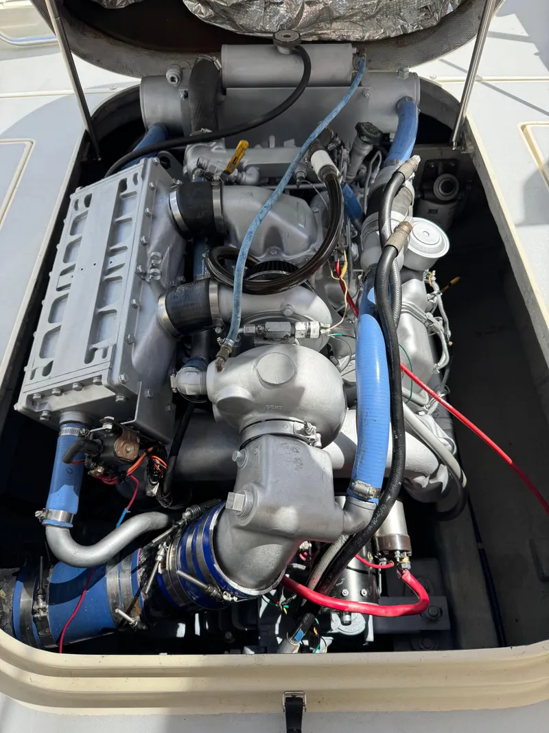 Slide: The Image of Engine of a 1996 Albin Tournament Express boat with blue hoses and metallic components. - 33