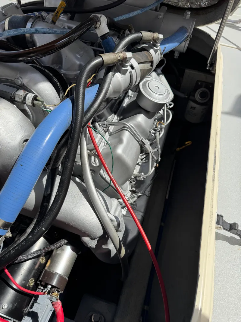 Slide: The Image of Engine compartment of a 1996 Albin Tournament Express boat, featuring various hoses and components. - 35