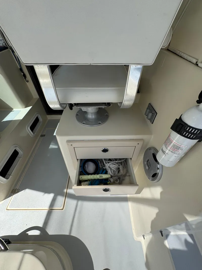 Slide: The Image of Interior of a 1996 Albin Tournament Express boat with storage drawer and fire extinguisher. - 9