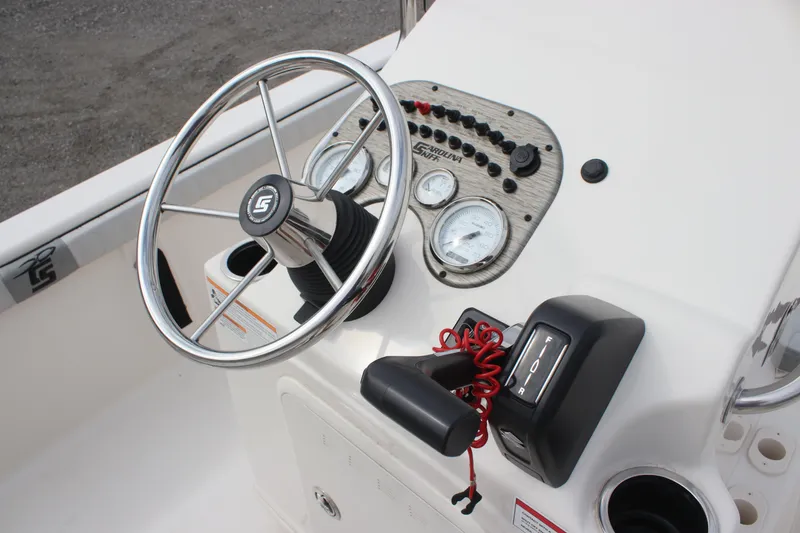 Slide: The Image of 2024 Carolina Skiff 21 LS boat dashboard with steering wheel and control panel. - 18