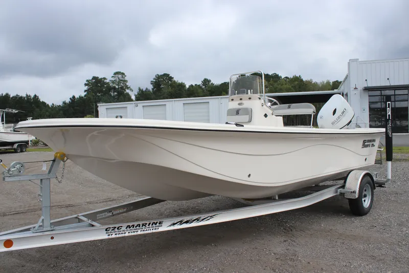 Slide: The Image of 2024 Carolina Skiff 21 LS boat on trailer, parked outdoors near storage facility. - 2