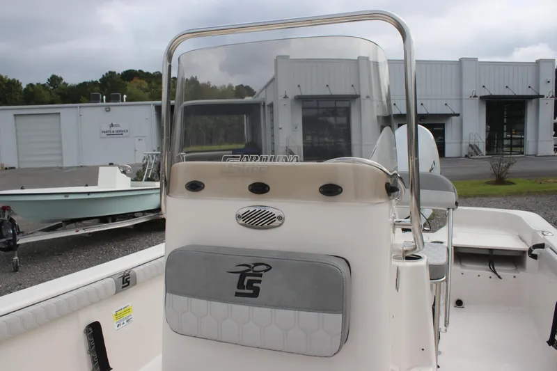 Slide: The Image of 2024 Carolina Skiff 21 LS boat console with windshield and seating, docked outdoors. - 24