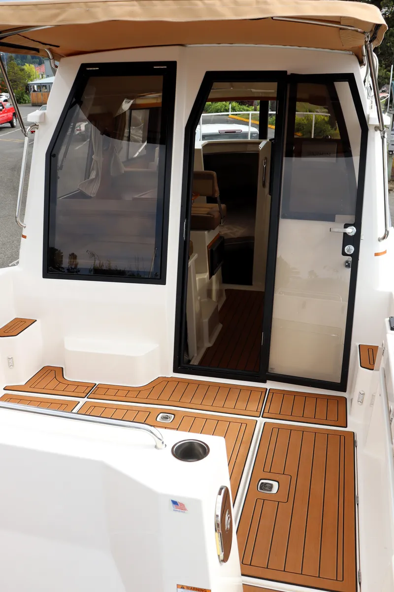 Slide: The Image of 2022 Ranger Tugs R-25 boat with teak deck and enclosed cabin. - 13